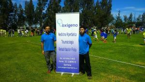 Gerardo Burboa y Claudio Romero junto al pendón de Oxígeno en el III Festival de Menores 2015 